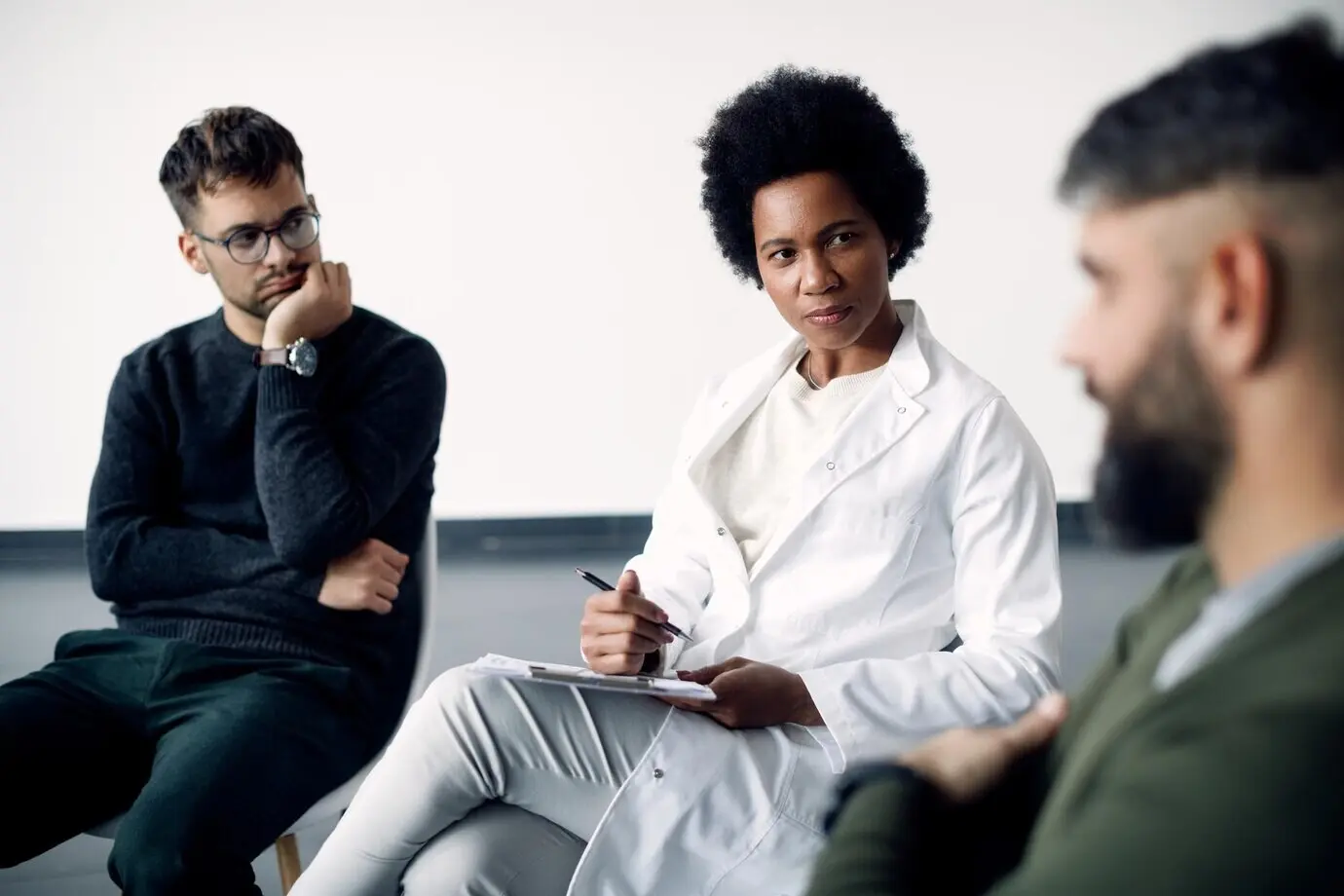 Afro-Amerikaanse psychotherapeut die een sessie heeft met een groep mensen.